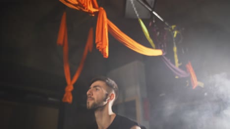 hombre trabajando con kettlebell, gimnasio de niebla oscura