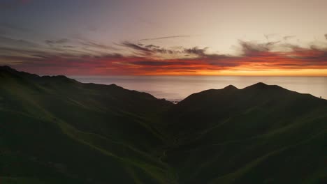 Impresionante-Y-Colorida-Puesta-De-Sol-En-El-Horizonte-Sobre-El-Océano-Con-Un-Paisaje-Montañoso-En-La-Playa-De-Kiritehere