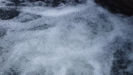 corriente de agua en una mini cascada con burbujas en un invierno frío