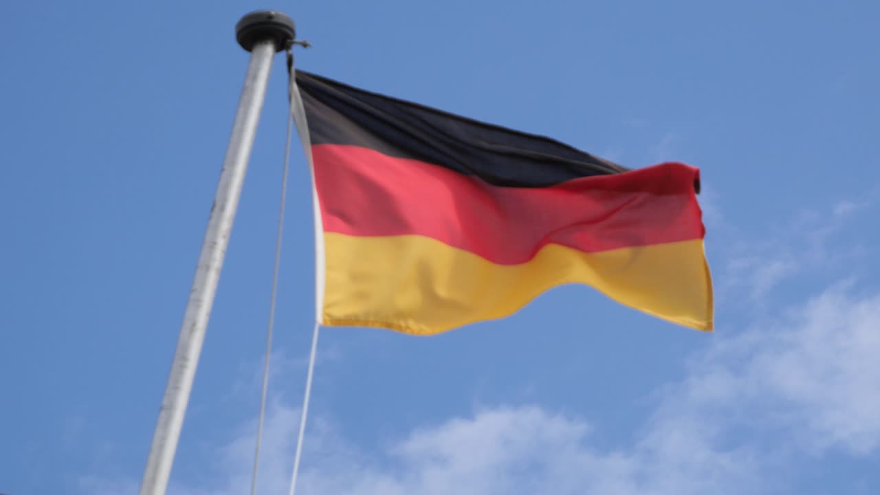 German Flag on a Flagpole Waving in the Wind on a Ship against Blue Sky