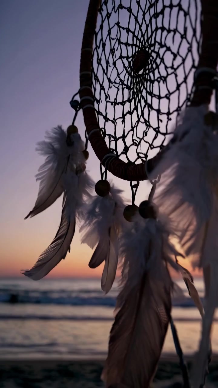 Acchiappasogni che ondeggia al vento su una spiaggia al tramonto