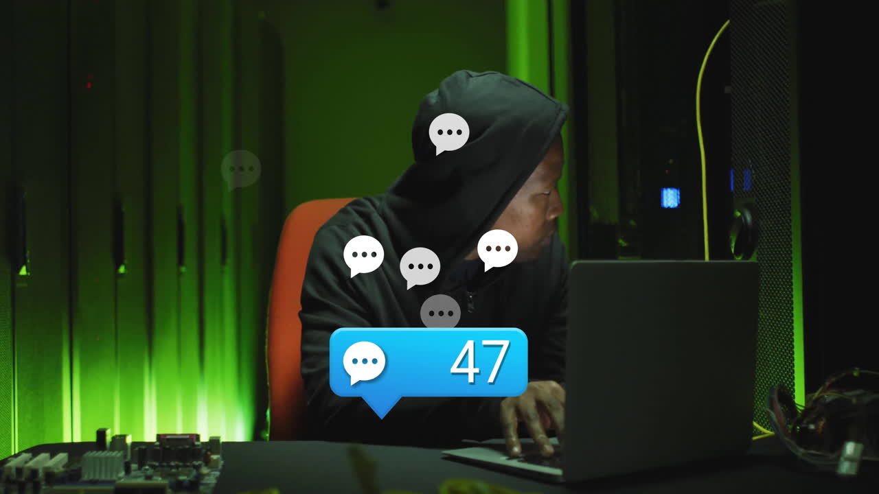 Using laptop in dark room, person in hoodie receiving chat notifications