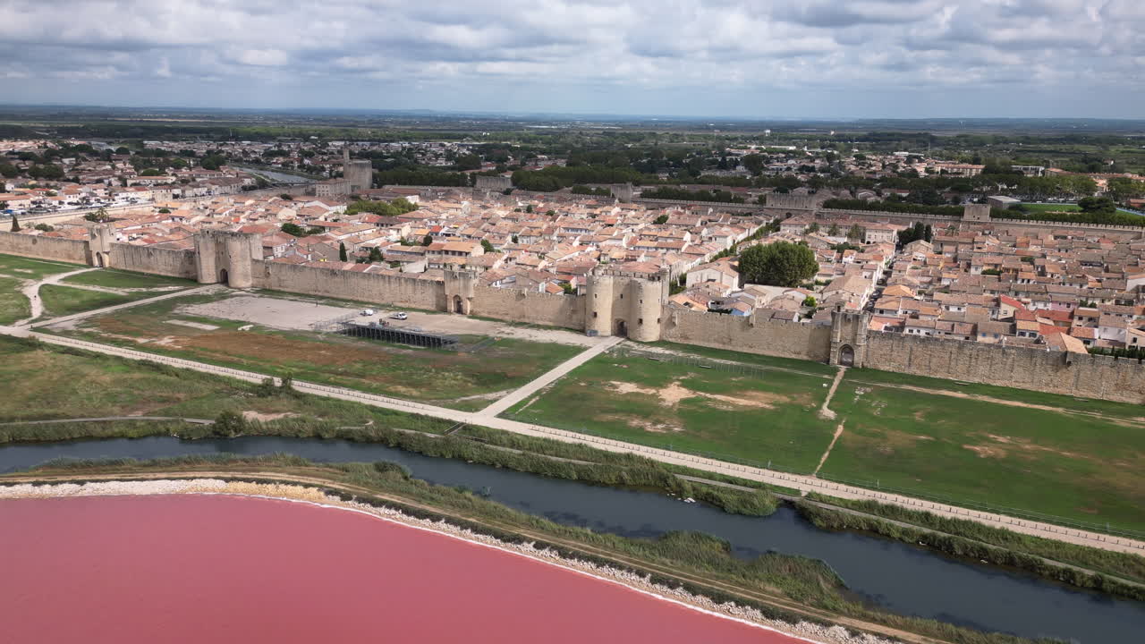 toma de un dron de un casco antiguo en francia con un mar rosado frente a él