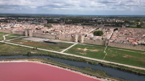 drone shot of a old town in france with a pink sea in front of it