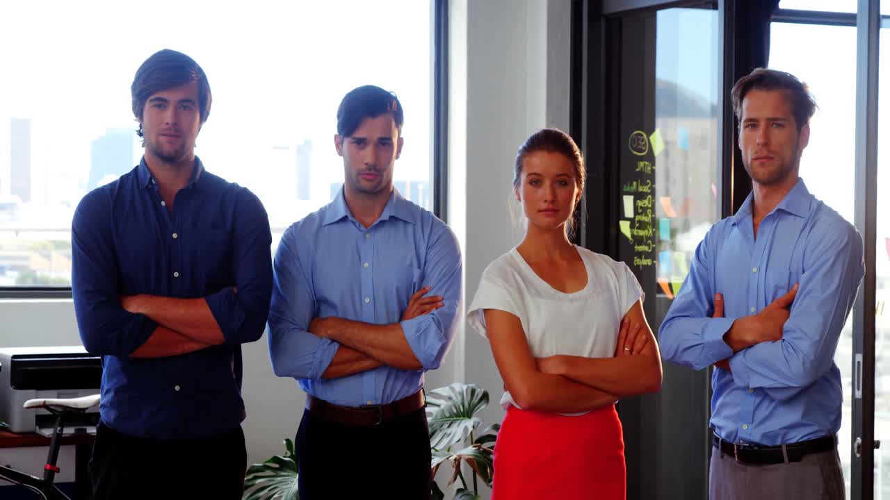 ejecutivos de negocios confiados de pie con los brazos cruzados en la oficina