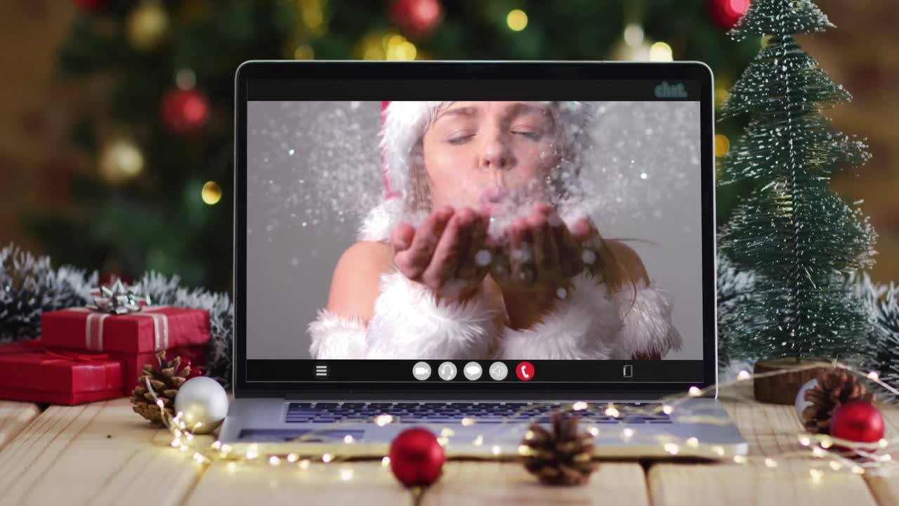 feliz mujer caucásica en disfraz de santa en videollamada en computadora portátil, con decoraciones de navidad y árbol