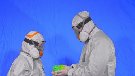 doctor in respirator show a virus model. slow motion. woman wearing protect medical aerosol spray paint mask. green ball spike thorn.