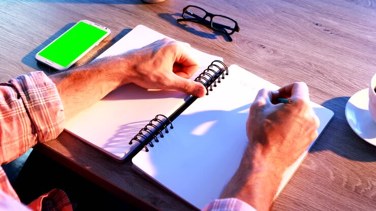 Male executive writing in diary at his desk 4k
