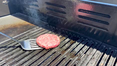 cooking hamburger patty on outdoor grill