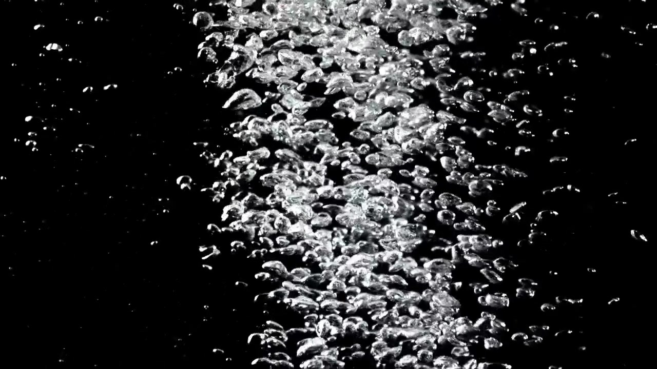 Stream of Clear Air Bubbles Rising on Black Background