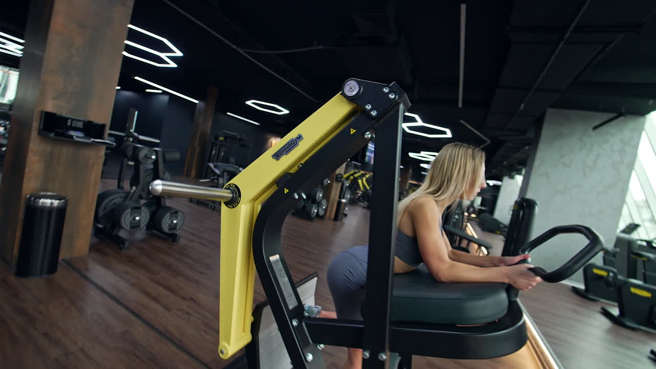 Woman exercising on leg press machine in a gym