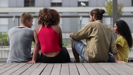 vista de atrás de amigos sentados en la calle