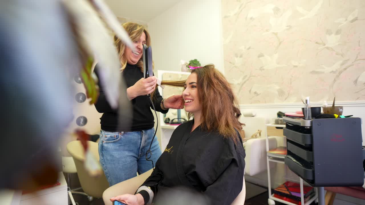 Happy Woman Getting Hair Styled by Hairdresser in Beauty Salon