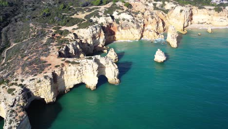 Mosque-Beach-and-Marinha-Beach-to-the-right-in-south-of-Portugal,-Aerial-orbit-reveal-shot