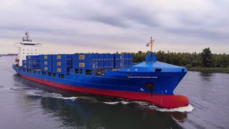 Container-Ship-Tailwind-Panda-002-Loaded-With-Container-Cargos-Sailing-On-A-Cloudy-Sunset