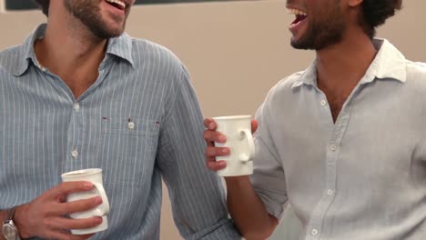 una pareja gay bebiendo una taza de café.