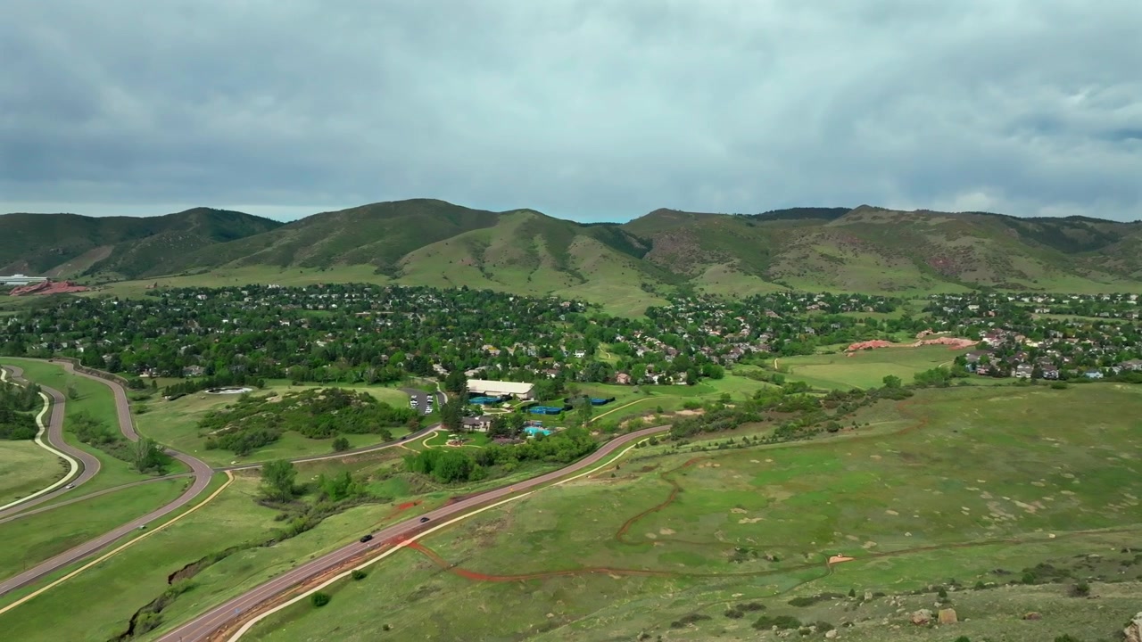Ken Caryl Valley Ranchin yhteisökeskus kesäisenä aurinkoisena aamuna sinisen taivaan alla. Meadow Ranch South Valleyn polun sisäänkäynti Denverissä, Coloradossa. Ilmakuva dronella Front Range Kalliovuorten juuresta, panorointi vasemmalle.