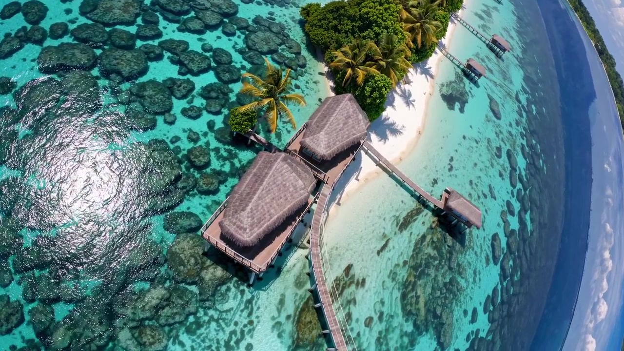 Vista aérea de bungalows sobre el agua en laguna tropical