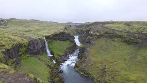 Aerial-high-above-the-famous-natural-landmark-and-tourist-attraction-of-Skogafoss-falls-and-Fimmvorduhals-trail-in-Iceland