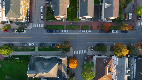 colorful autumn fall foliage leaves on trees along quiet street in usa