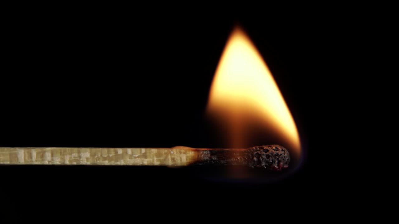 fósforo ardiendo lentamente en el fuego dejando cenizas negras de palo leñoso, concepto de medio ambiente macro shot