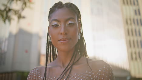 woman touching braids looking camera posing sunbeams square portrait