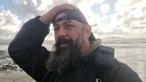 hombre barbudo con gorra de béisbol en cámara lenta comprobando las nubes para el cambio de clima