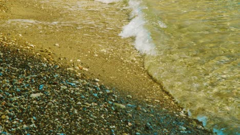 sea waves washing up on a rocky beach shore in willemstad, curacao on a sunny summer day