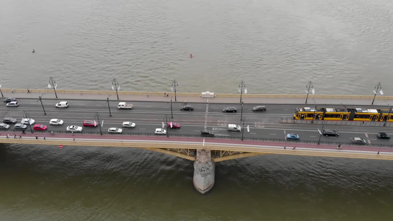 교통 체증과 노란색 트램이 있는 강 위의 다리의 공중 전망