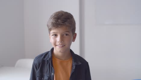 Happy-Caucasian-boy-standing-in-classroom