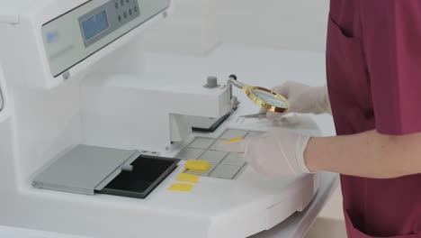 the laboratory assistant conducts a histological examination, microtoming. the section of the rotary microtome for the diagnosis of pathology makes a histological microscope slide. waxing a tissue sample.