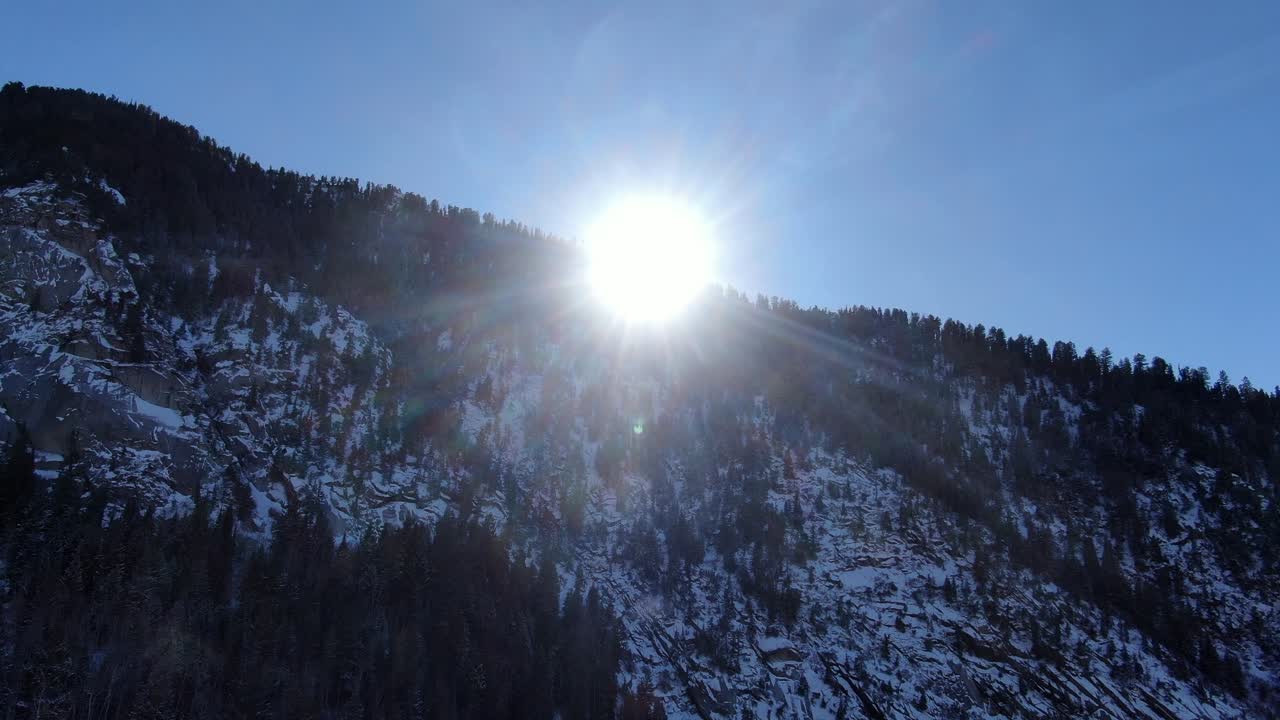 SMUKT LUFTFOTO AF SOLEN, DER VISER SIG I VINTERBJERGENE.