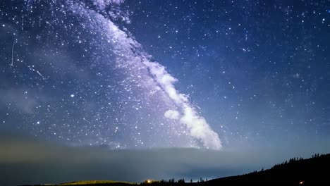 milky way galaxy gliding across a starry night sky above a distant city, showcasing the beauty of the cosmos