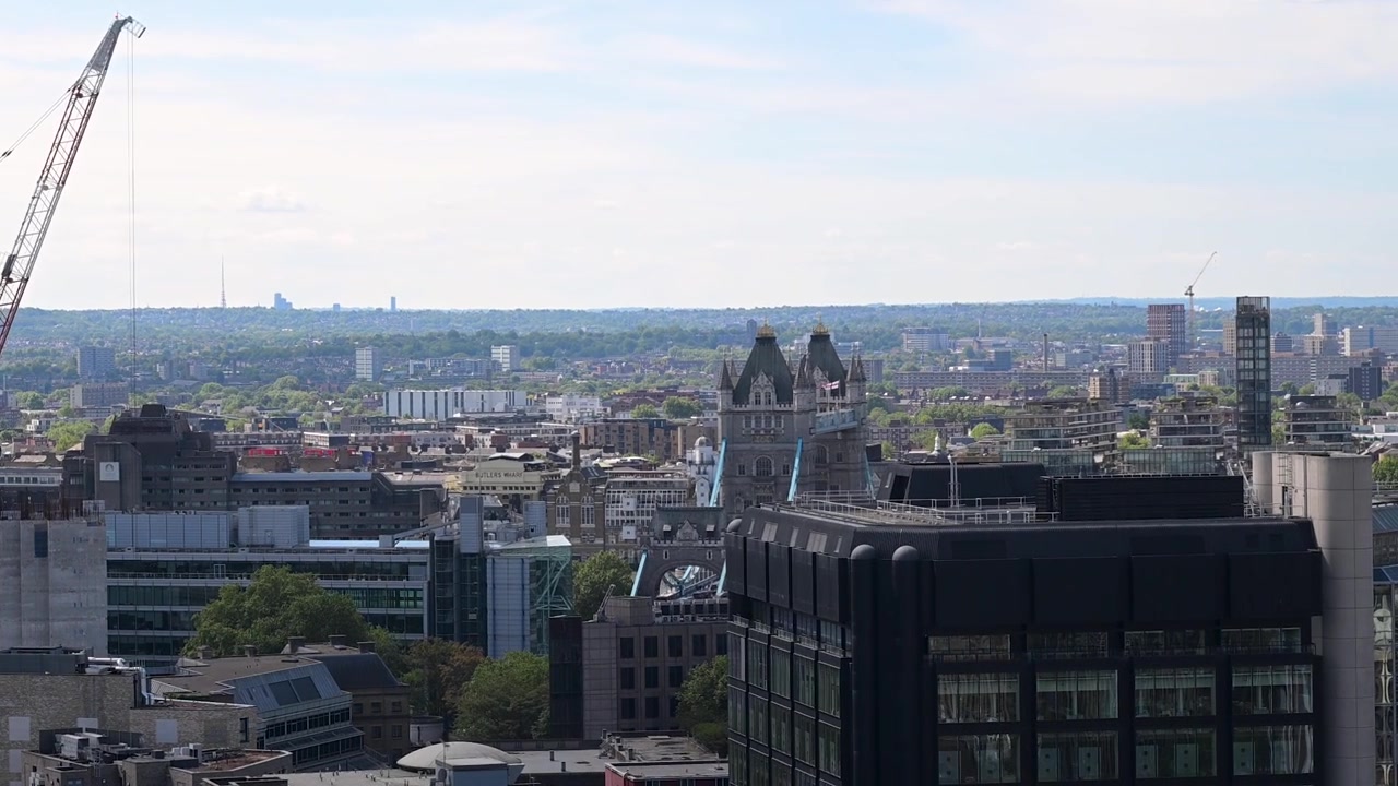 Una prospettiva panoramica elevata dell'iconico Tower Bridge e del fiume Tamigi, visti da un tetto nel cuore del quartiere finanziario.