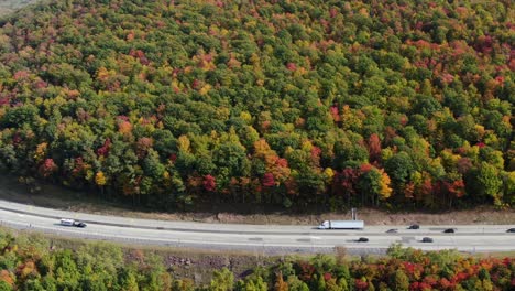 vehicles, trucks, cars travel on interstate highway in united states of america, usa american vacation, logistics, transportation, commuting concept in beautiful nature, peak autumn fall foliage