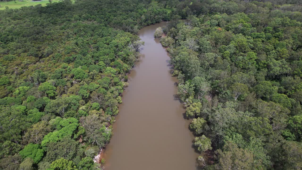 Calm Brown Waters Of Brunswick River Through Lush Green Forest In New South Wales, Australia. aerial shot