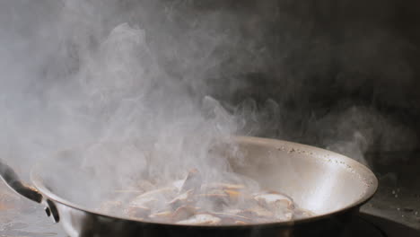 mushrooms being sautéed in a hot pan