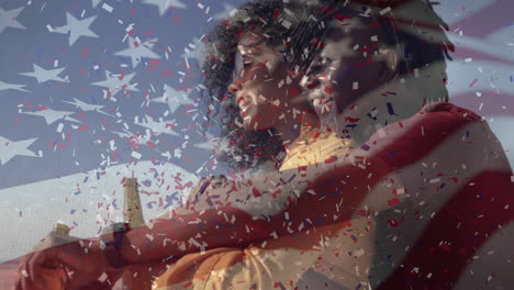 animation of american flag waving confetti falling over biracial couple holding beer bottles