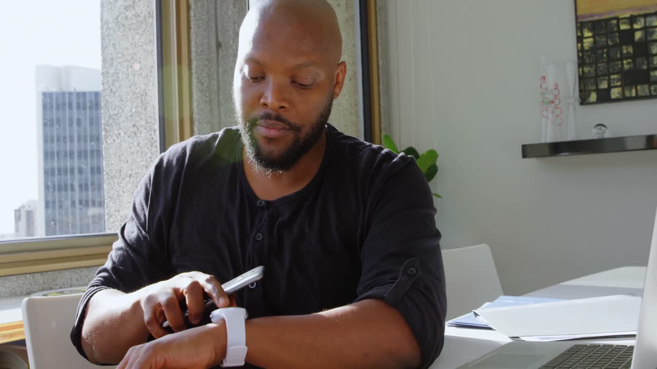 Man using smartwatch and mobile phone in a comfortable home 4k