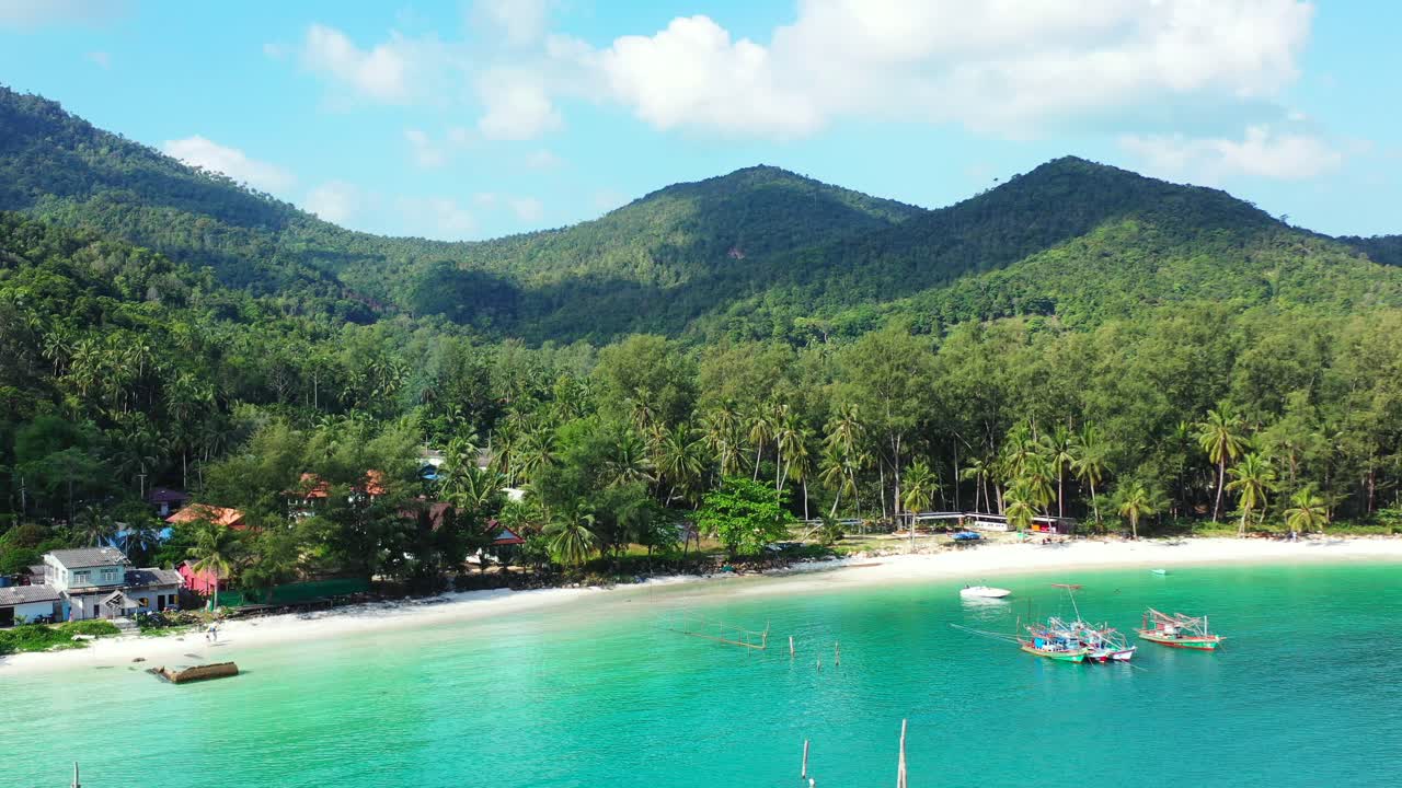 Playa de arena blanca y resorts de lujo en una isla tropical, Koh Phangan, Tailandia. Montañas con bosque de palmeras al fondo.