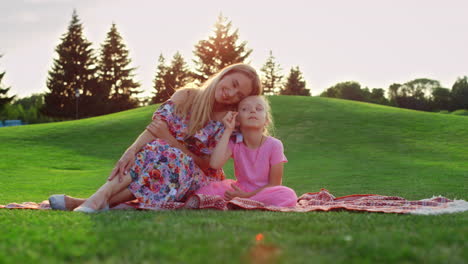 Familie-Posiert-Bei-Sonnenuntergang-Auf-Der-Wiese.-Frau-Umarmt-Mädchen-Im-Stadtpark.