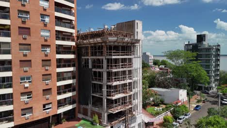 Intriguing-drone-perspective-revealing-the-emergence-of-a-new-building-beside-an-older-one,-symbolizing-urban-transformation-and-the-juxtaposition-of-architectural-eras