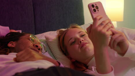 couple in bed looking at phone