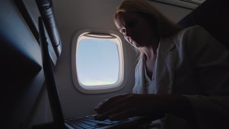 Business-Woman-Using-Laptop-In-Flight