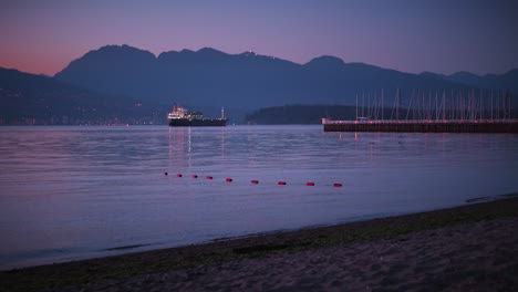 Late-evening-at-Jericho-beach-Vancouver,-Pacific-ocean,-ships,-boats,-Cross-Mountain-and-Vancouver-Downton-in-the-background