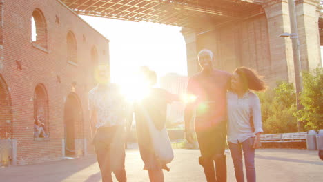 Group-Of-Friends-Walking-By-Brooklyn-Bridge-In-New-York-City