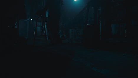 mysterious man in the workshop at night smokes a cigarette