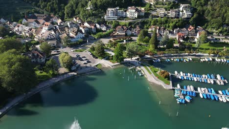 rising aerial view of beautiful lakeside swiss town and marina