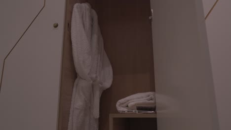 white bathrobe hanging on rack