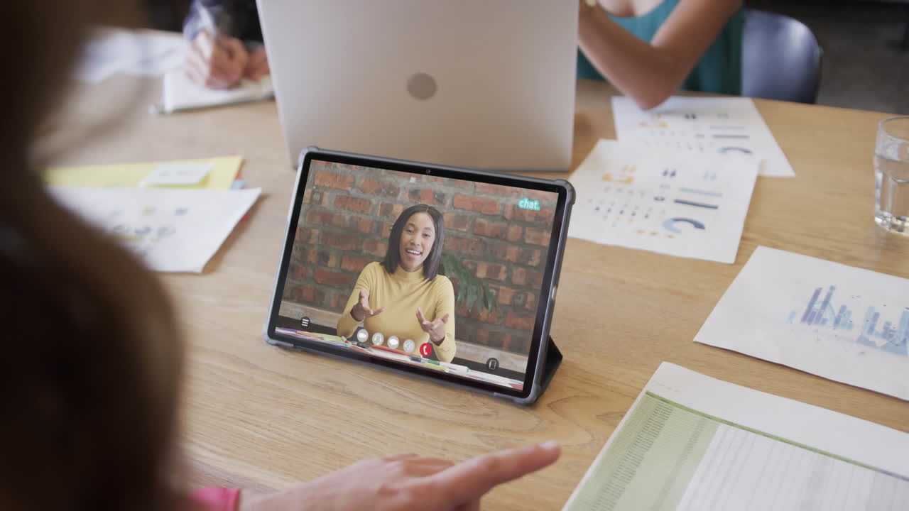 mujer de negocios caucásica en una videollamada con una colega afroamericana en la pantalla